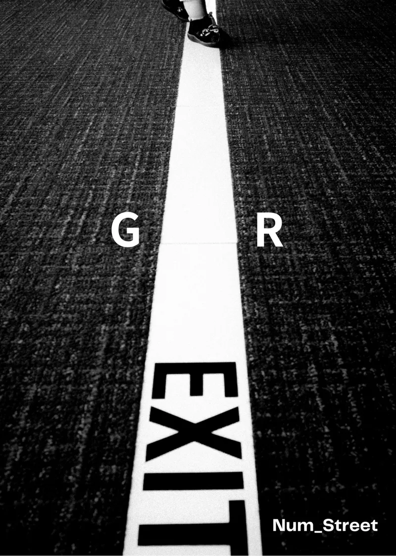 アスファルトに引かれた白い矢印と EXIT の路面標示を写したモノクロの表紙